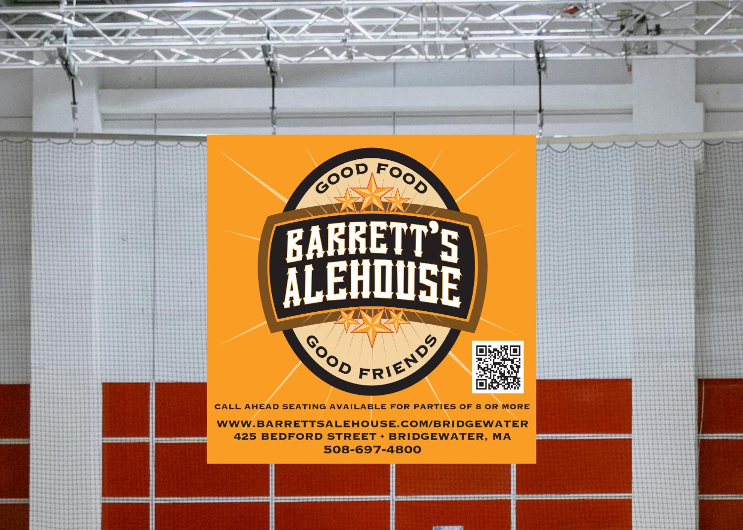 A banner hanging in an ice rink displaying an ad for a local alehouse.